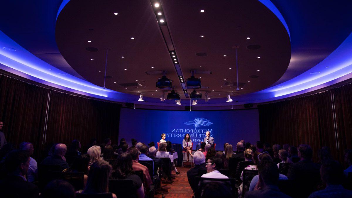 Vicente Fox event photo with three people speaking on stage in the CAVEA theater at 密歇根州立大学丹佛